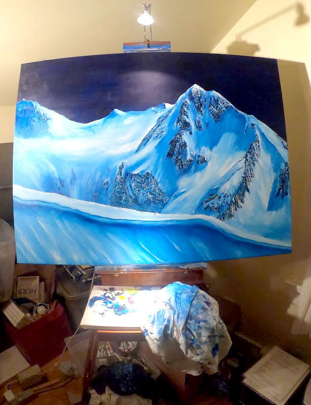 oil Painting of a mountain art landscape on an easel with art supplies around. by graham watts
