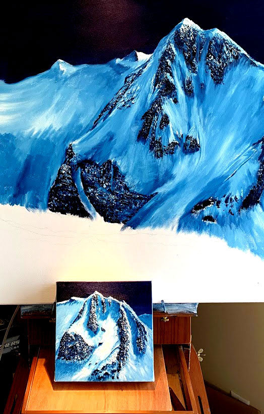 canadian artist graham watts  Realistic mountain painting on a table with a smaller version of the same painting displayed. 